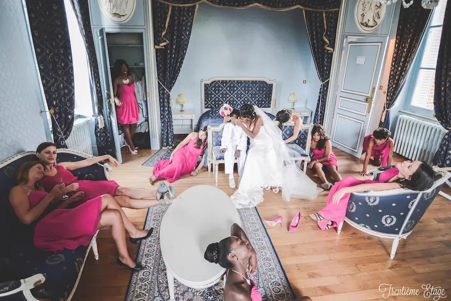 Les demoiselles d&rsquo;honneur en robes fuchsia, dispers&eacute;es dans la chambre bleue du ch&acirc;teau