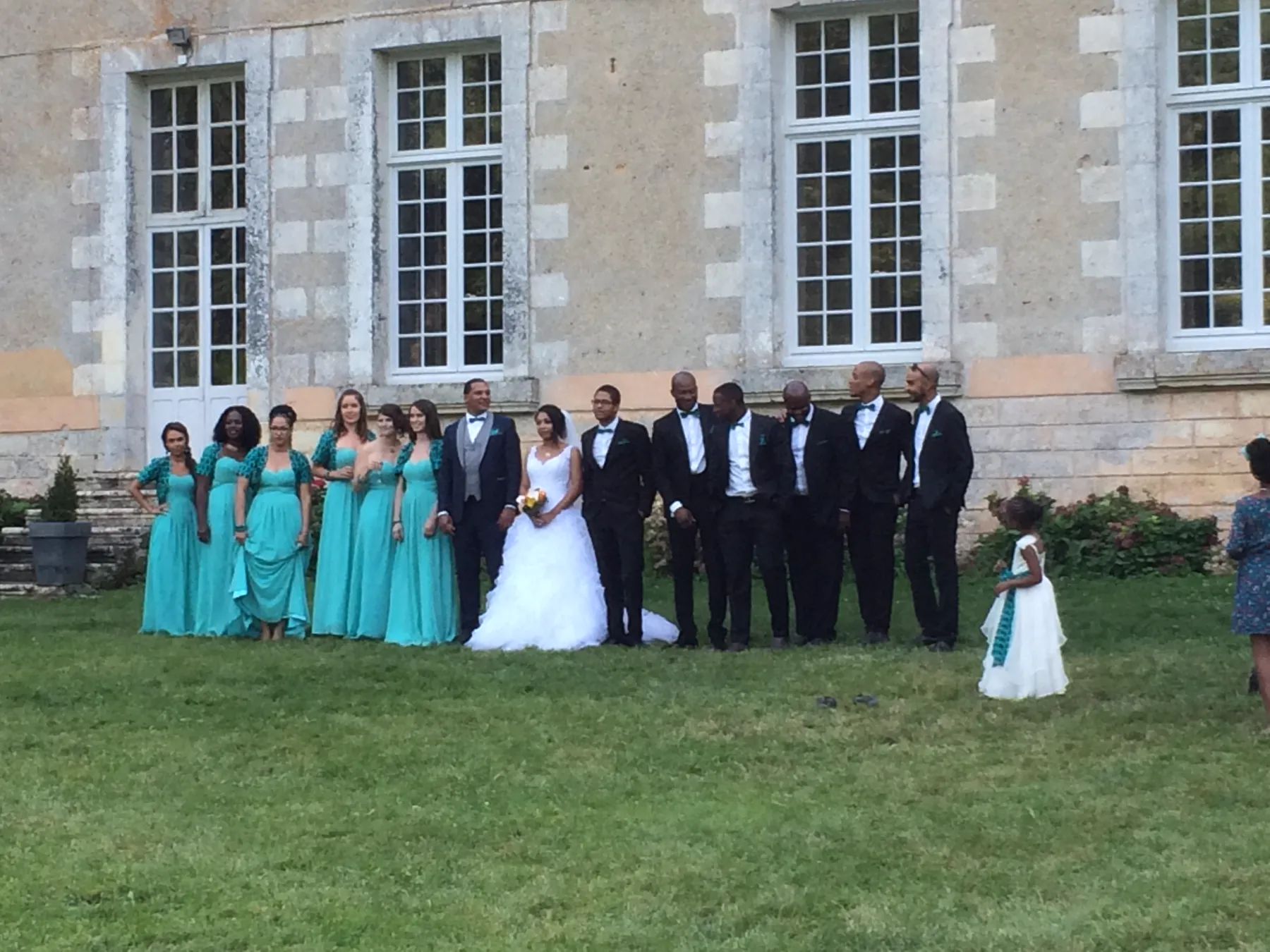 Le cortège aligné devant la façade de l’abbaye, et la petite demoiselle d’honneur qui s’est éloignée sur le côté