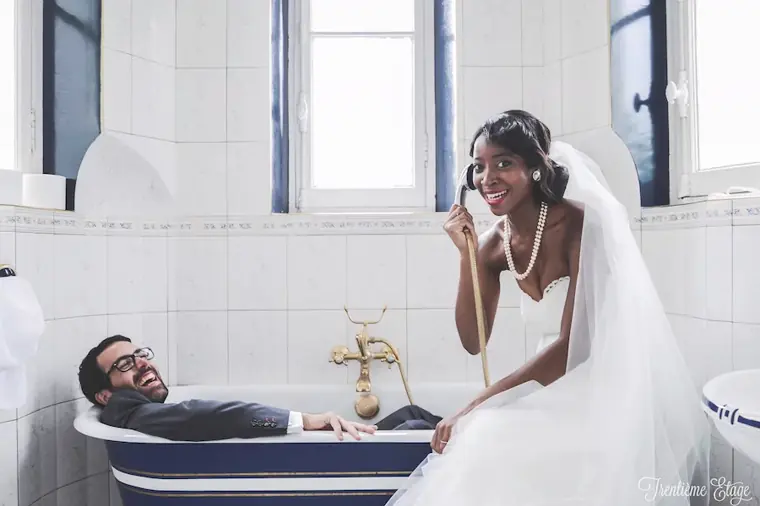Les mari&eacute;s dans la salle de bain du ch&acirc;teau, lui allong&eacute; tout habill&eacute; dans la baignoire