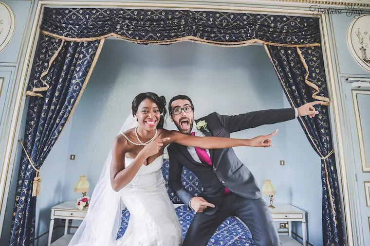 Photo de mariage originale: les mariés sont montés sur le lit et font une pause rigolote
