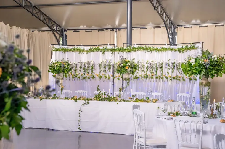 Le mur de fleurs suspendues derrière la table des mariés