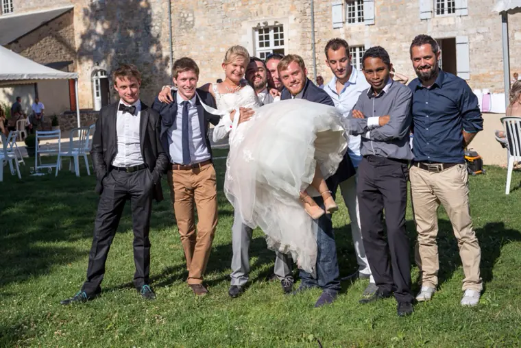 La mariée portée par les témoins, devant les bâtiments de l’abbaye