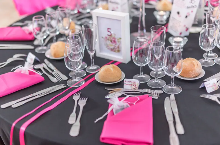 Le couvert : nappe noire, serviette fuchsia, numéro de table encadré