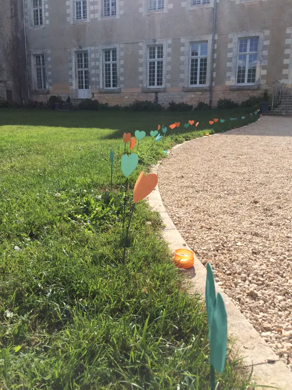 L’allée de gravier qui mène aux bâtiments abbatiaux, balisée de bougies