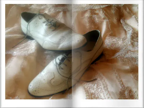 Les chaussures bicolores du marié, posées sur la robe