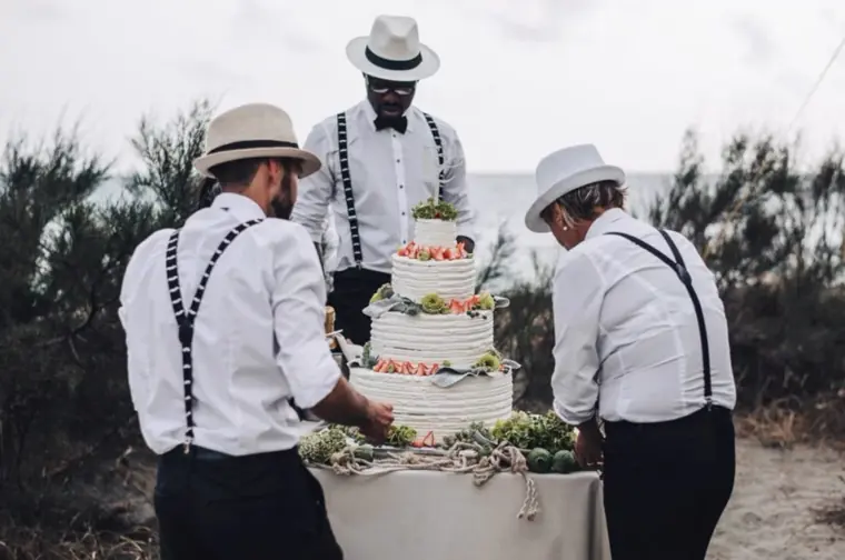 les garçons d'honneur portent le gâteau de mariage