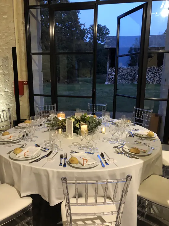 Centre de table : fleurs blanches, eucalyptus et bougie