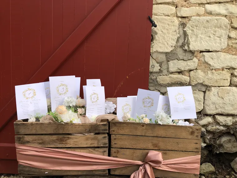 Le plan de table, présenté sur des caisses de bois contre la porte rouge de la grange