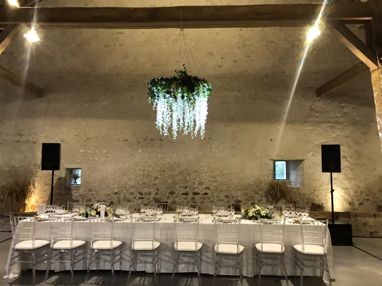 La table d’honneur, en longueur, sous un lustre de feuillages suspendus