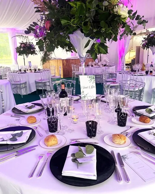 décoration de table de mariage avec une assiette de présentation noire et un vase martini