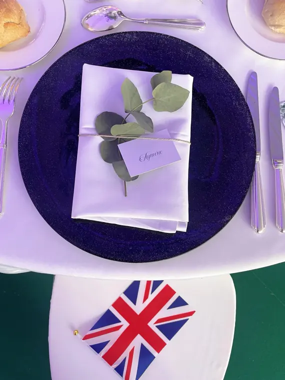 Assiette noire sur la table de mariage. Eucalyptus dans l'assiette. Drapeau anglais pour les invités