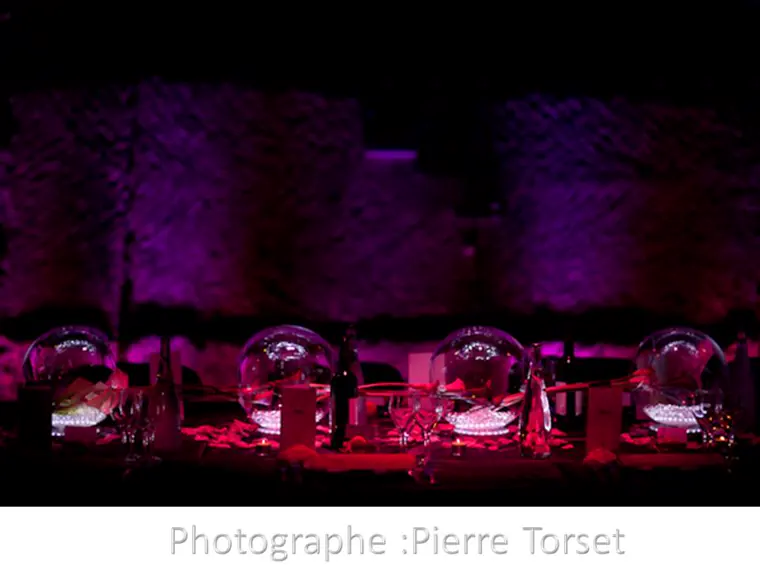 La table dressée devant la paroi de pierre lavée de violet