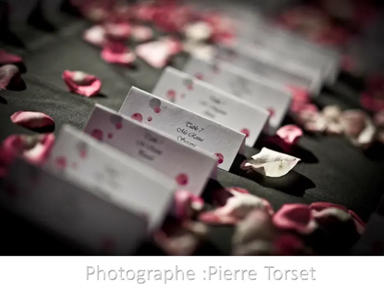 Les marque-places posés parmi les pétales de rose