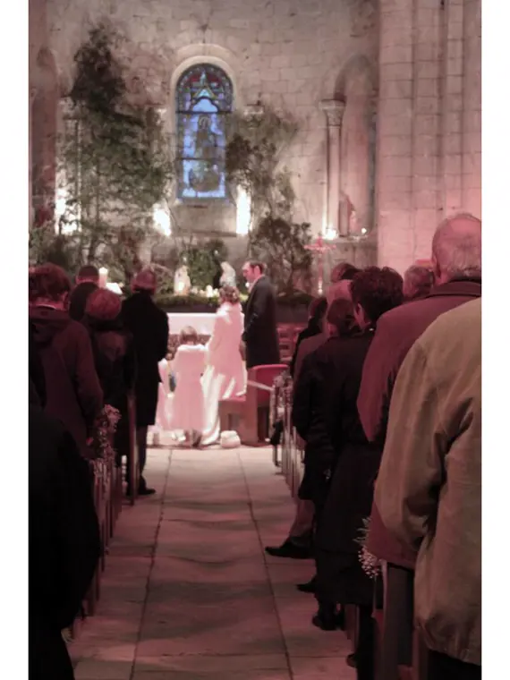 cérémonie religieuse d’hiver, les invités assis en manteau dans une église romane