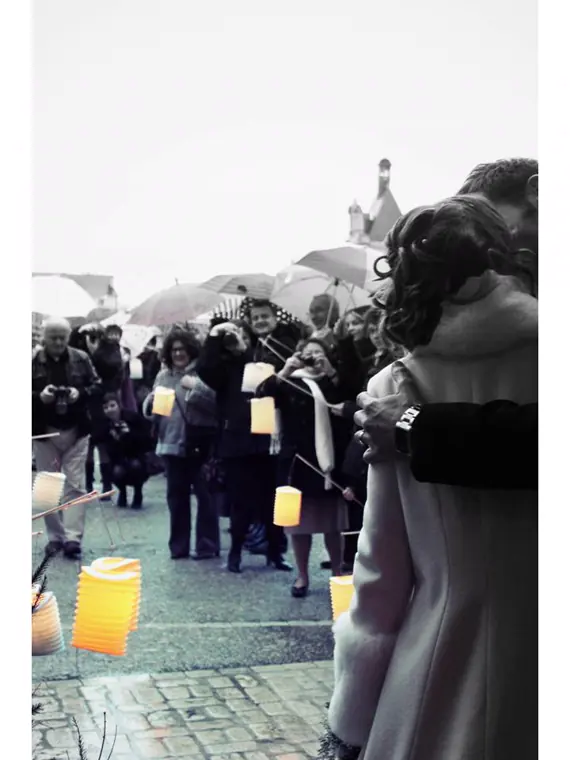 sortie d’église en hiver sous les parapluies, les invités tiennent des lampions allumés