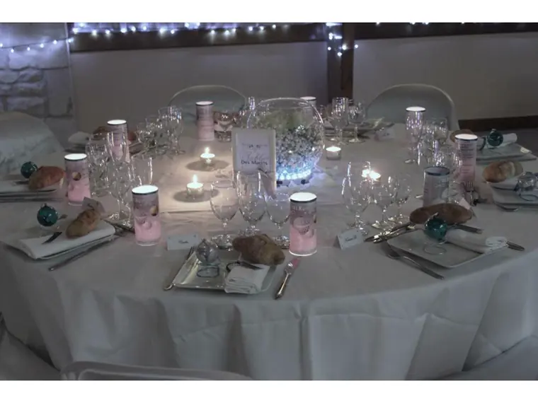 table ronde dressée en blanc et turquoise, guirlandes lumineuses au mur