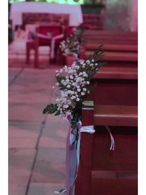 bout de banc fleuri au premier plan et le chœur de l’église au fond