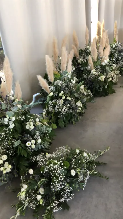 L’allée de la cérémonie, bordée de pampas et de fleurs blanches