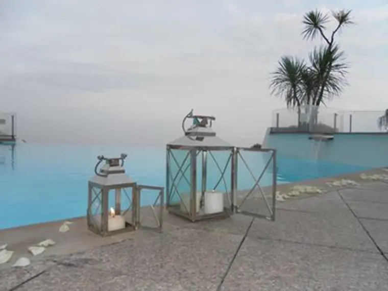 Deux lanternes et des pétales au bord du bassin à débordement, face à la mer