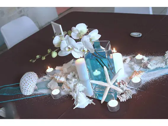 centre de table : orchidees blanches, vases carres remplis d eau turquoise, coquillages et etoiles de mer