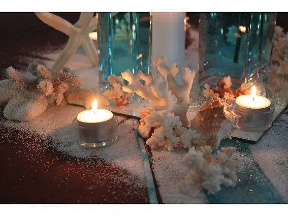 coraux blancs et bougies chauffe-plat disposes autour d un vase turquoise