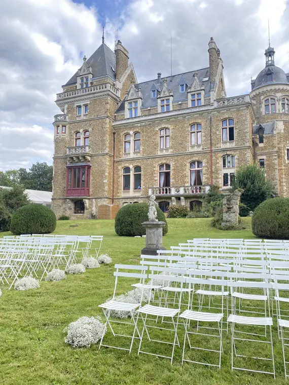 Les chaises blanches alignées sur la pelouse, face à la façade du château