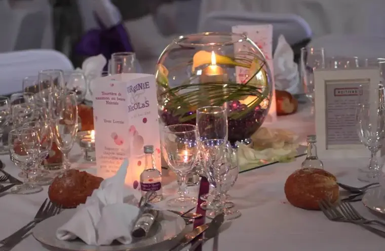 La table dressée le soir, bougie flottante dans un bocal de verre et menu debout