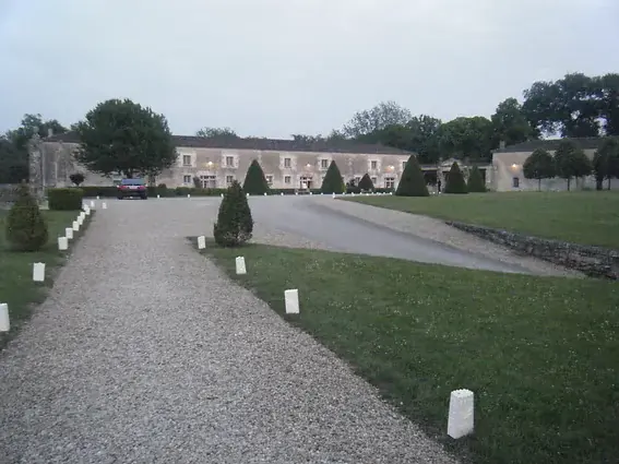 L’allée du château jalonnée de lanternes, au crépuscule