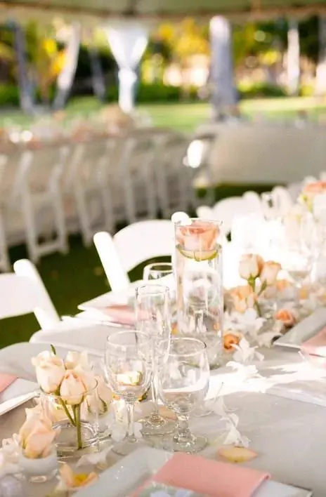rose orange immergée dans vase sur table de mariage