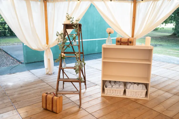 Décor d’accueil composé d’une échelle en bois, de cagettes et de valises anciennes