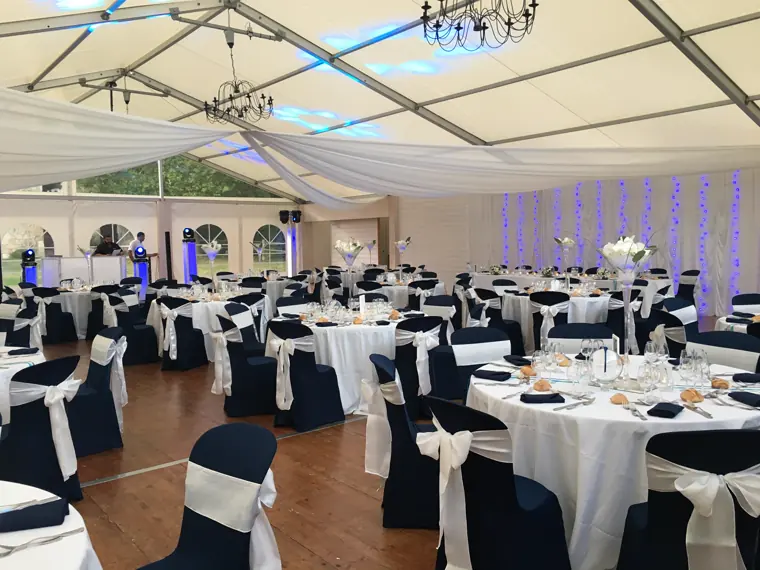 Le tivoli dressé : housses bleu marine à nœuds blancs, drapés et lustres noirs