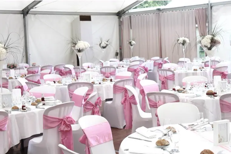 Le tivoli dressé : housses blanches à nœuds rose dragée et vases hauts