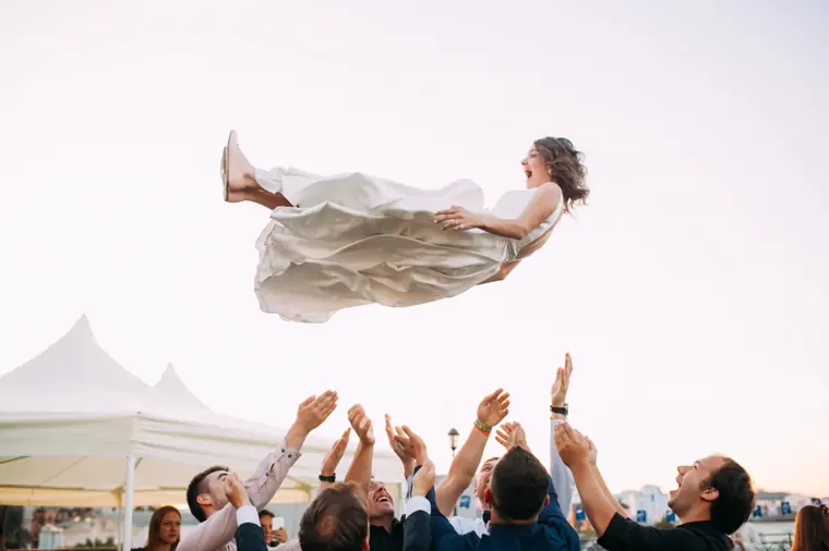 La mariée portée en l’air par ses invités, toutes les mains tendues vers elle