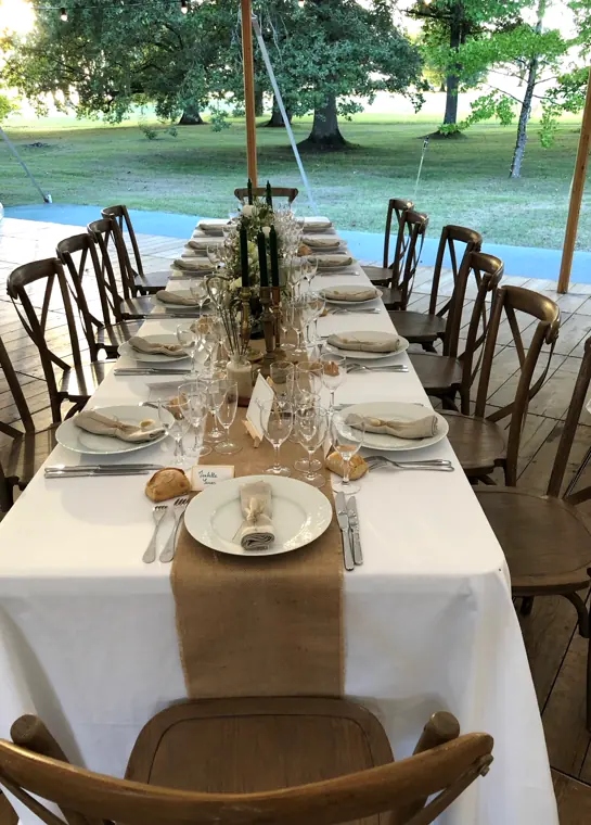 Le décor de table : bougeoirs dorés, verrerie et chemin de table végétal