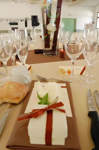 couvert dresse : serviette nouee d'un ruban, menu et petit pain