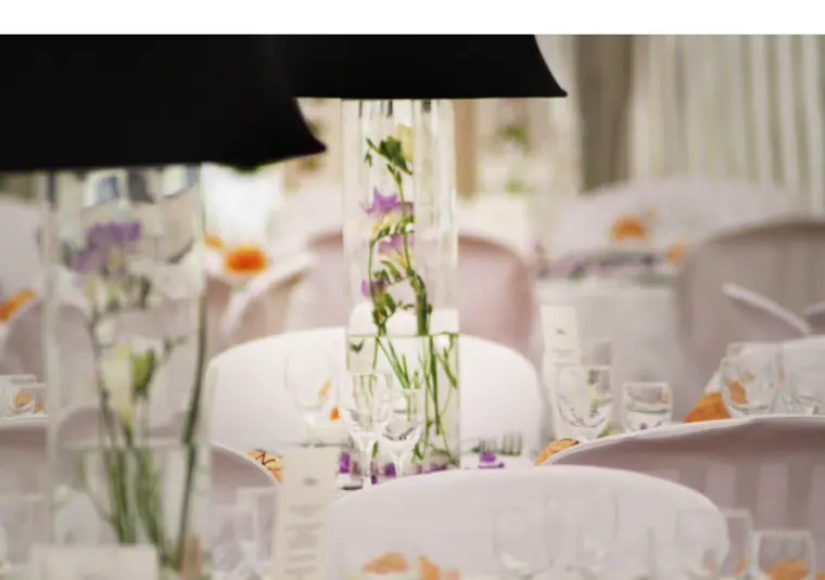 Le centre de table : vases hauts, frésias violets et abat-jour noirs