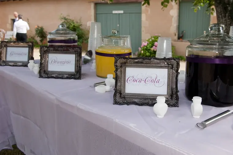 Le bar à boissons et ses bonbonnes, étiquetées dans des cadres anciens