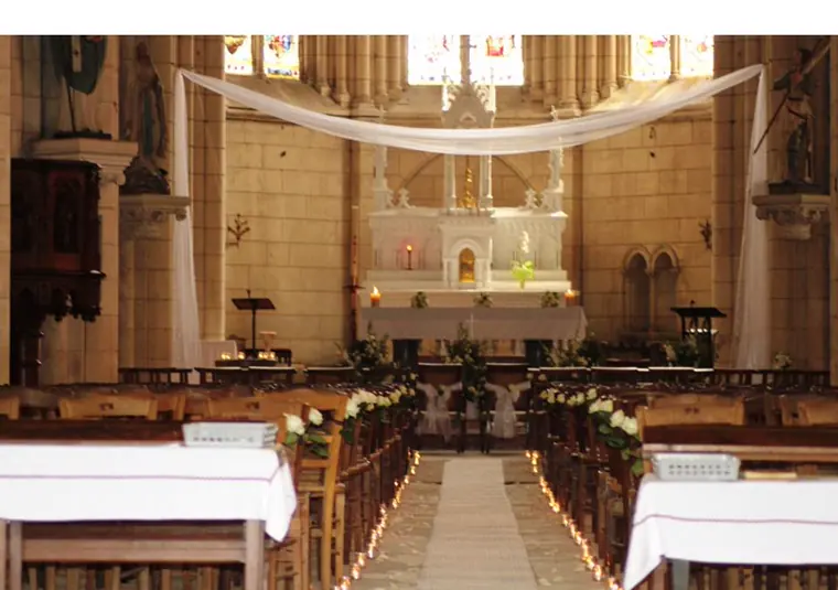 L’église drapée de voile blanc, l’allée bornée de bougies