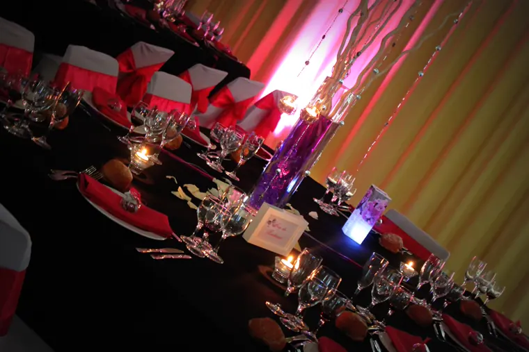 La table d’honneur en enfilade, verrerie et photophores, le mur lavé de rose et d’or