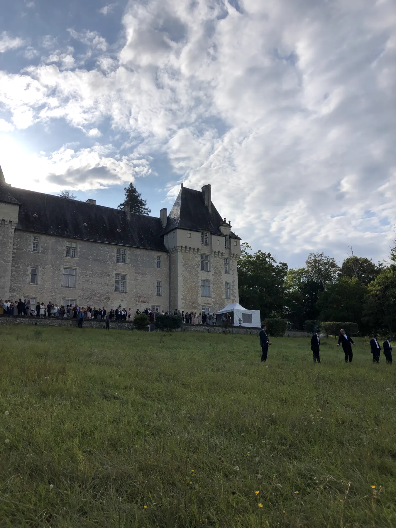 Le château de la Tour d’Oyré vu du parc, les invités alignés devant la façade