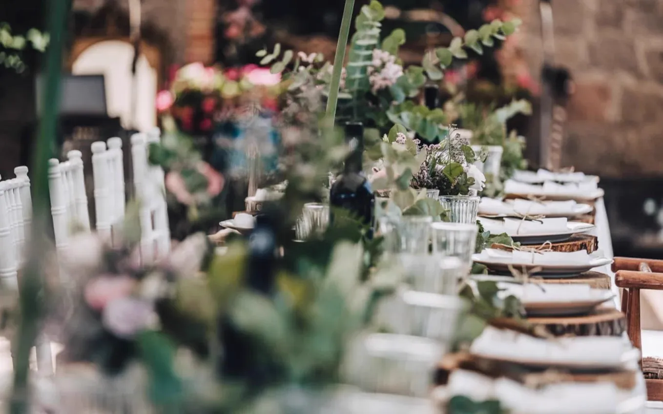 Longue table de mariage courue d&rsquo;un chemin d&rsquo;eucalyptus et de fleurs vieux rose