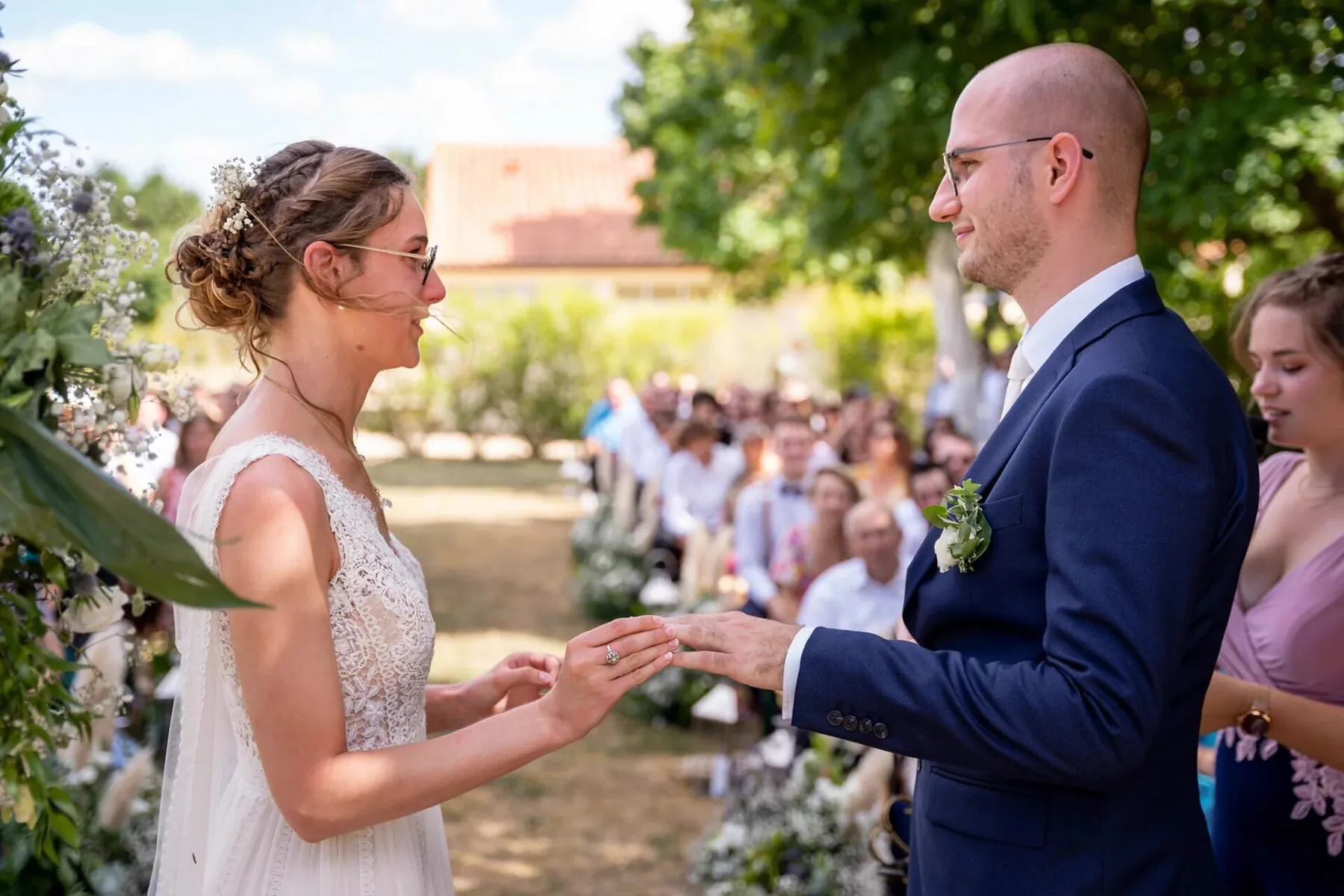 Les mari&eacute;s &eacute;changent leurs alliances en plein air, devant leurs invit&eacute;s