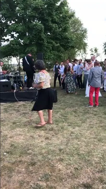 Un groupe de rock joue en plein air pendant le cocktail, les invit&eacute;s dansent dans l&rsquo;herbe