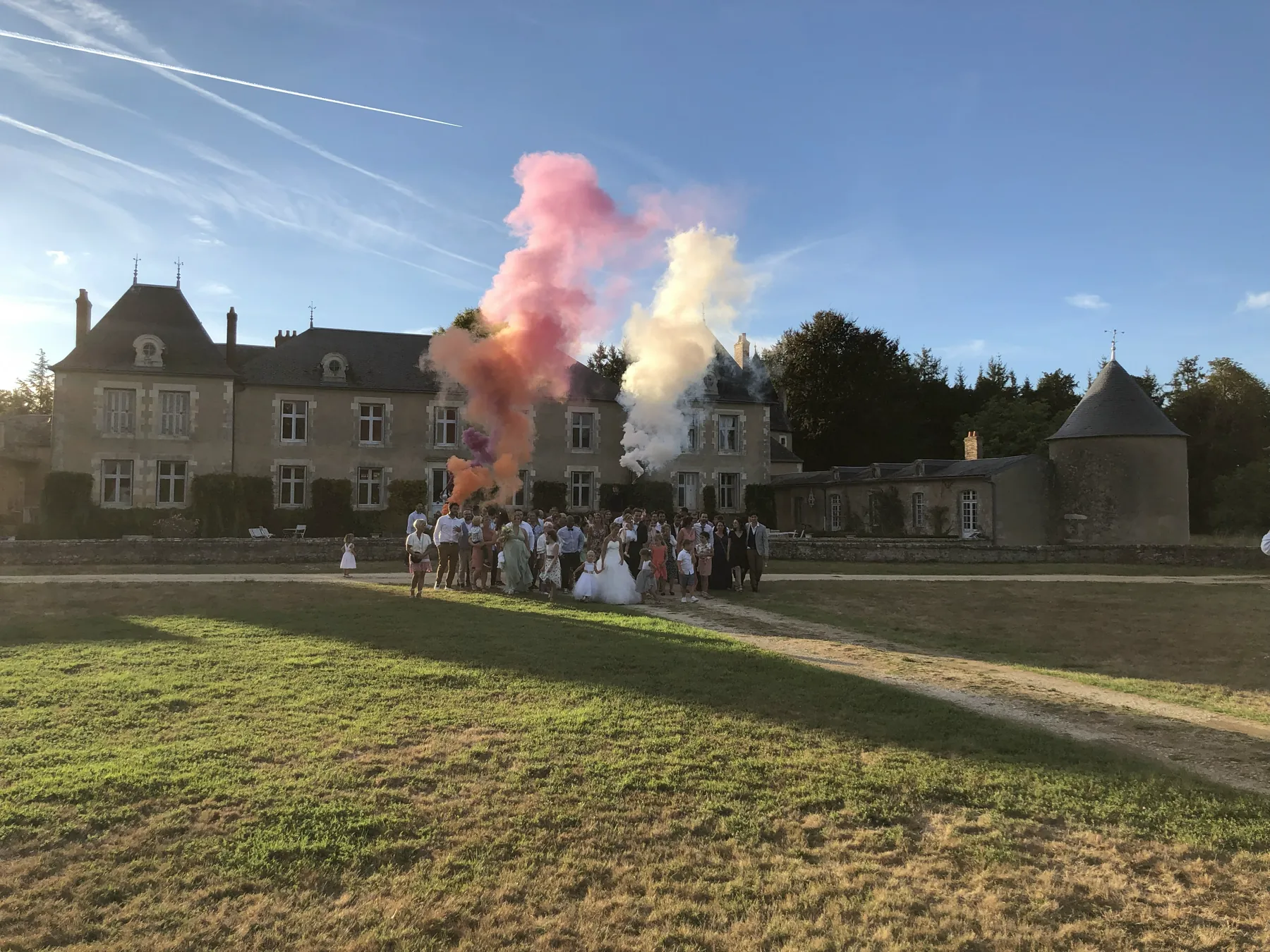 Le château de Mauprié et tous les invités réunis devant, au milieu des fumées roses et blanches