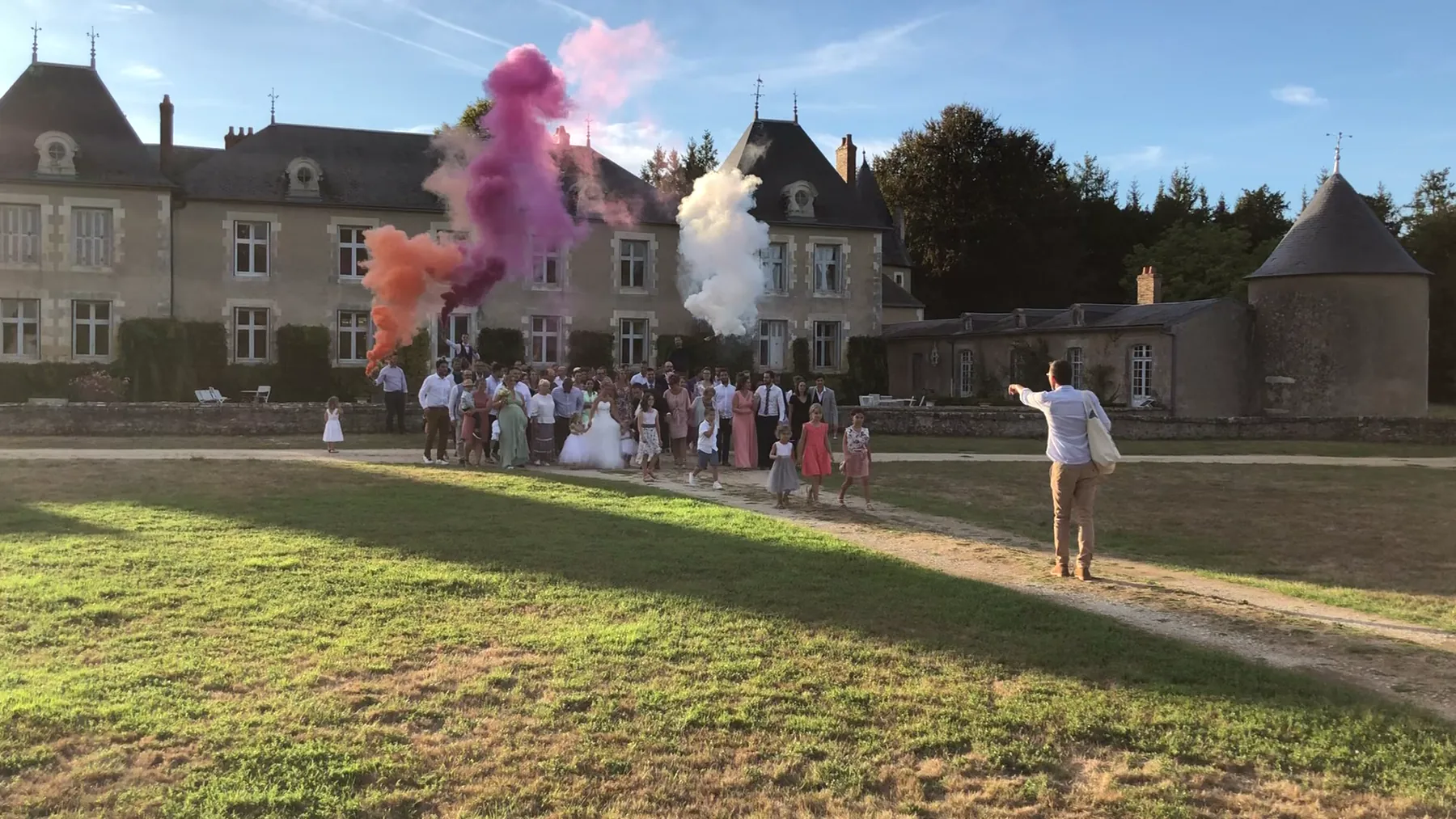 Les fumig&egrave;nes orange, rose et blancs devant la fa&ccedil;ade du ch&acirc;teau