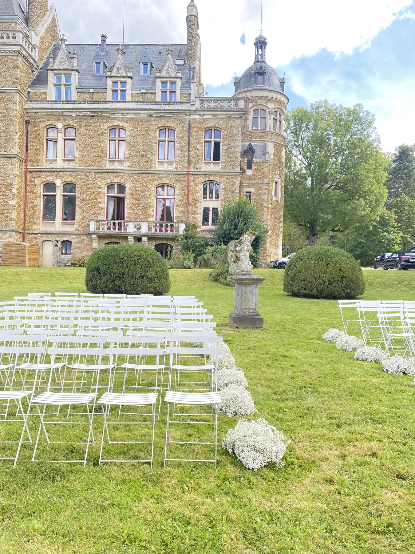 Les chaises de la cérémonie installées sur la pelouse devant la façade du château de Méridon