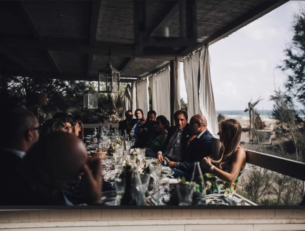 Une seule longue table sous une paillote ouverte sur la mer, une quinzaine de convives attablés