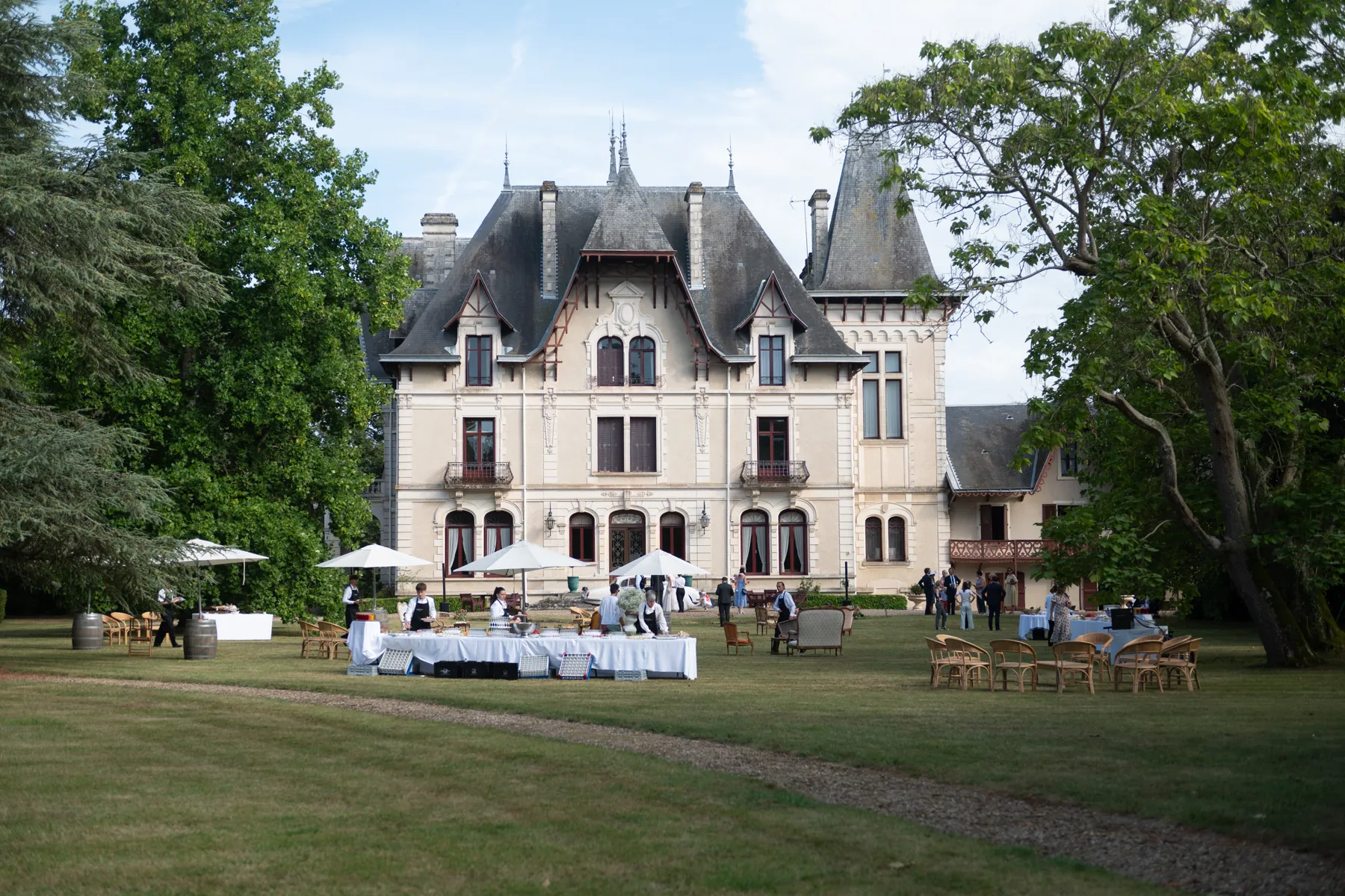 Le château du Coudreau et le cocktail installé sur la pelouse, sous les parasols blancs