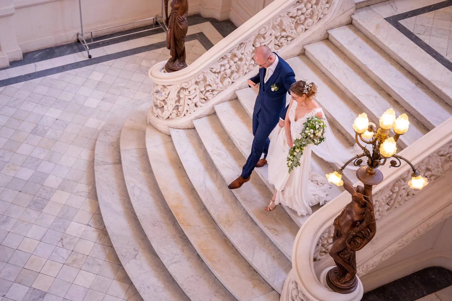 Les mariés descendant le grand escalier de la mairie de Poitiers, les invités en bas