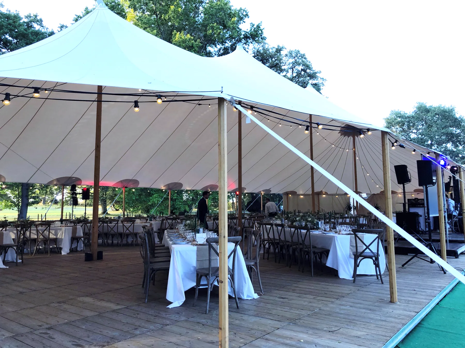 Une tente de r&eacute;ception ouverte sur le parc, les tables dress&eacute;es et pr&ecirc;tes avant l&rsquo;arriv&eacute;e des invit&eacute;s